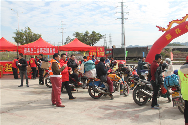 圖為藤縣總工會(huì)在省道304線藤縣陶瓷工業(yè)園區(qū)商業(yè)街小廣場設(shè)立藤縣總工會(huì)為農(nóng)民工平安返鄉(xiāng)“暖流行動(dòng)”服務(wù)站，積極為騎摩托車